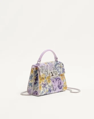 Mini bolsa Valentino Garavani Vsling com motivo Flowerism em strass e logotipo em joias